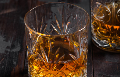 Single malt scotch whiskey in crystal glasses on wooden background