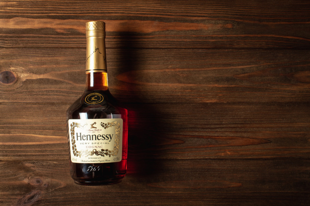 Henessy bottle on wood background - Flask & Barrel