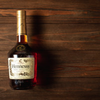 Henessy bottle on wood background - Flask & Barrel