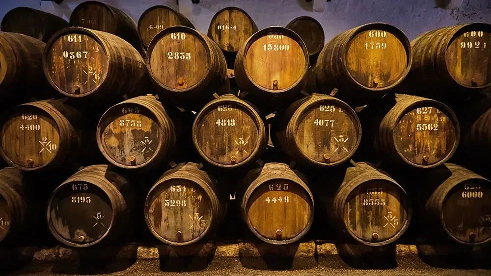 Whiskey casks aging in dim cellar.