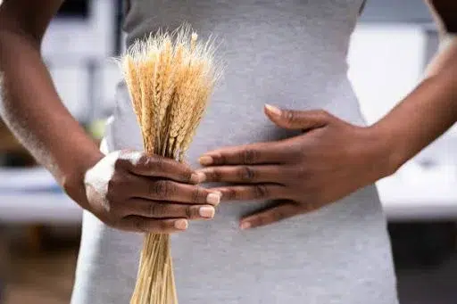 Person holding wheat bundle, close-up of hands.