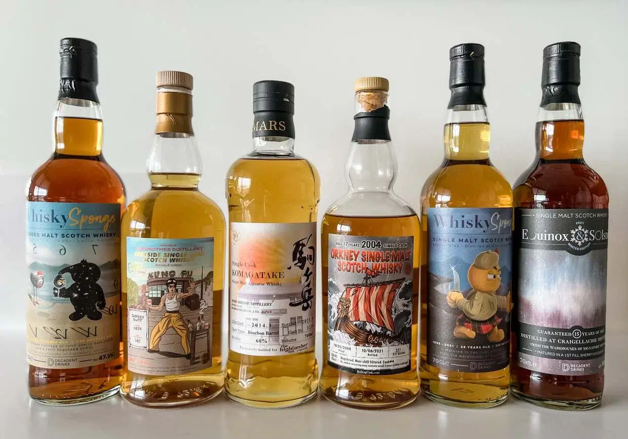 Assorted single indie whisky bottles on shelf.