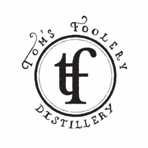 Tom's Foolery Distillery logo with monogram.