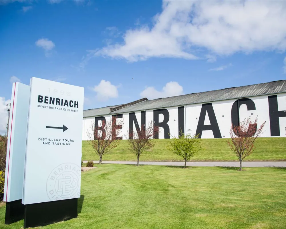 BenRiach Distillery exterior with sign for tours and tastings.