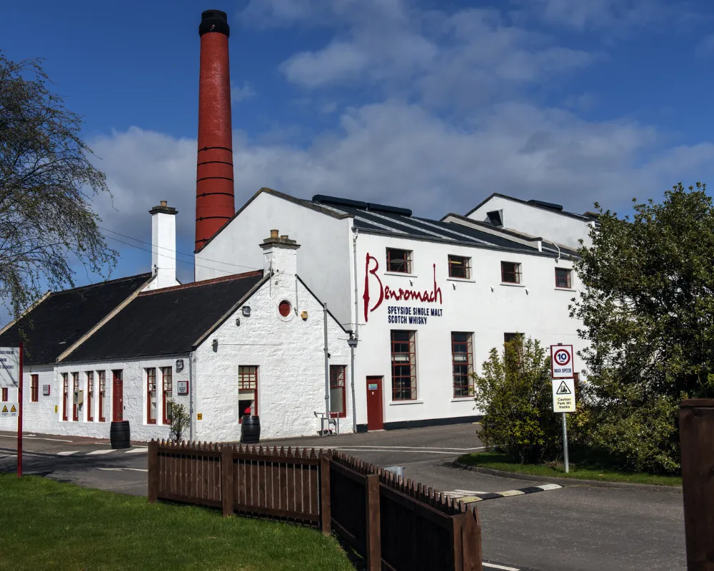 Benromach Distillery building with red chimney.