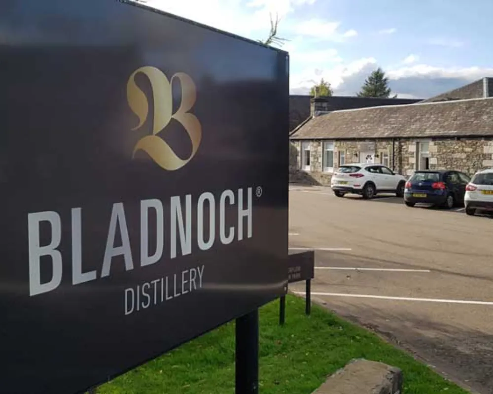 Bladnoch Distillery signage with stone building background.