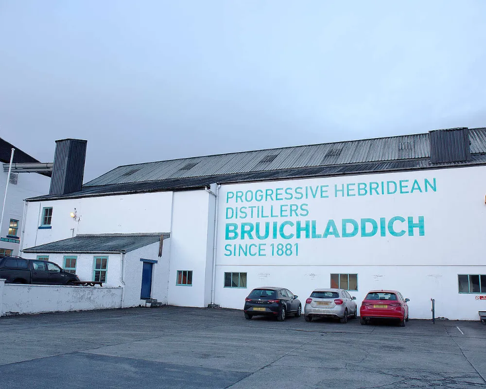 Bruichladdich distillery exterior with parked cars in Hebrides.