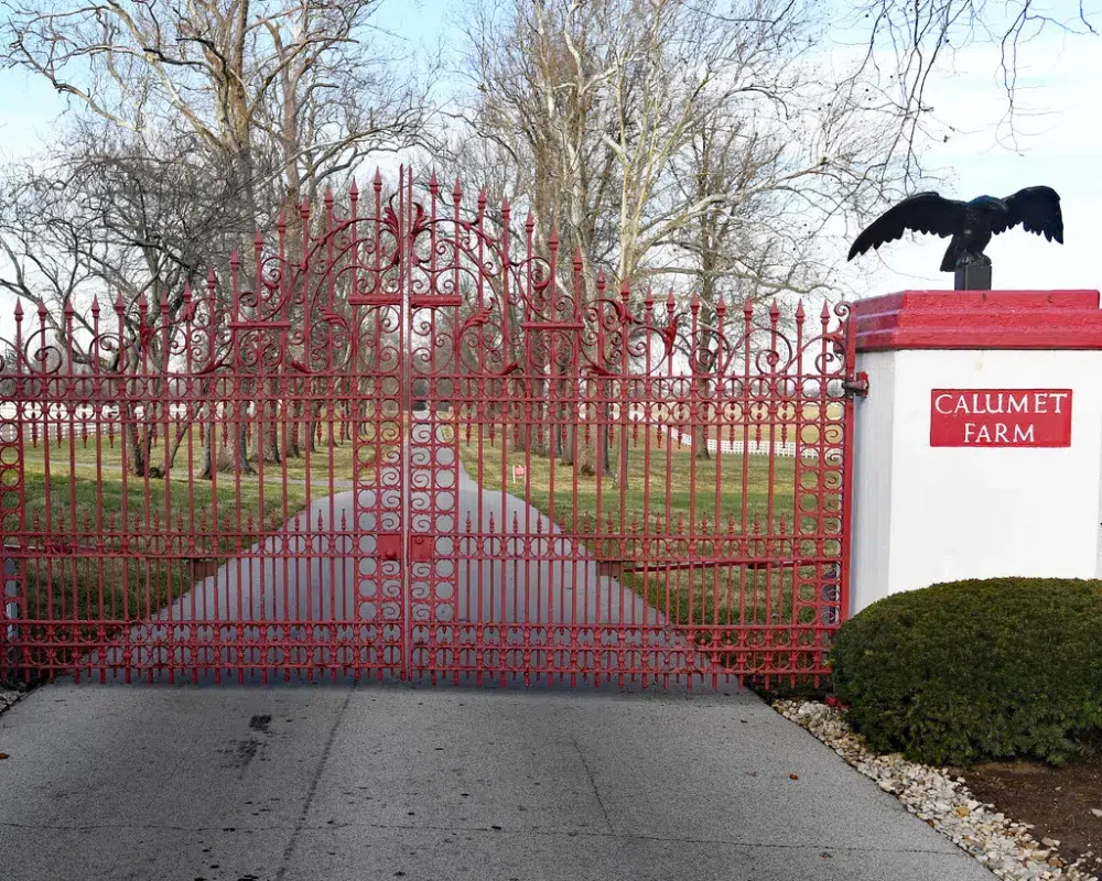 Red ornate gate with eagle, Calumet Farm entrance.