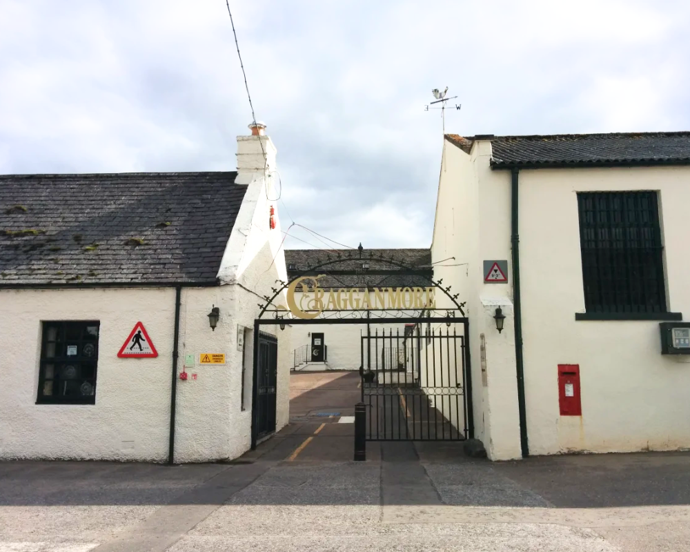 Cragganmore Distillery entrance gate and white buildings.