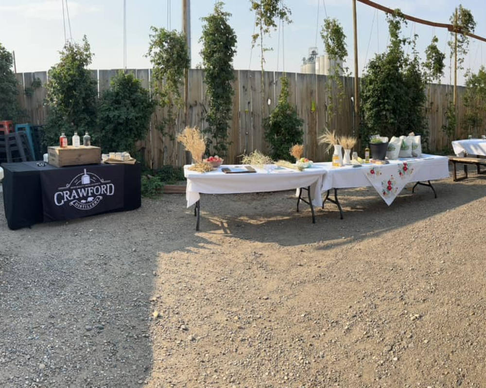 Outdoor event setup with tables and company banner.