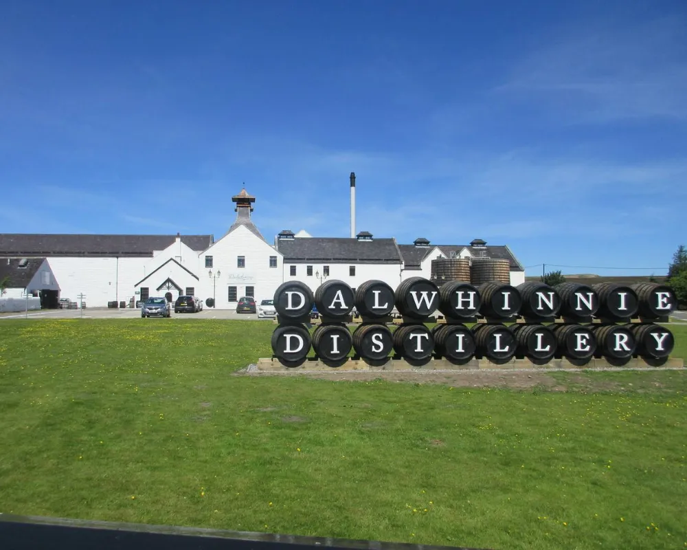 Dalwhinnie Distillery exterior with whiskey barrels sign.