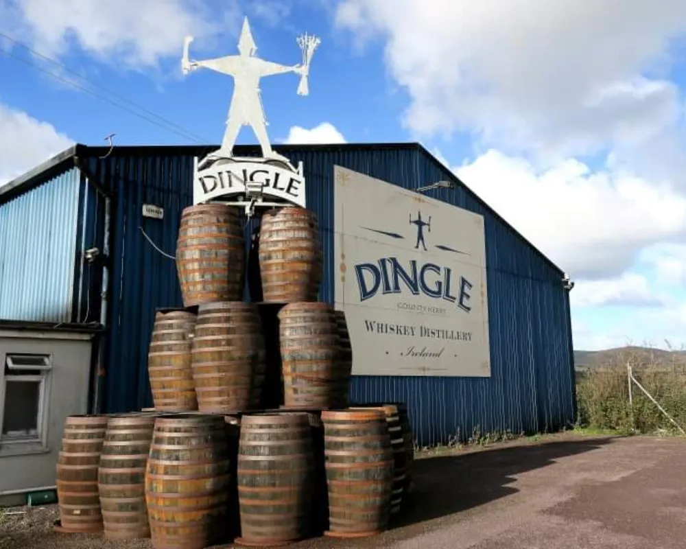 Dingle Whiskey Distillery in Ireland with barrels and sign.