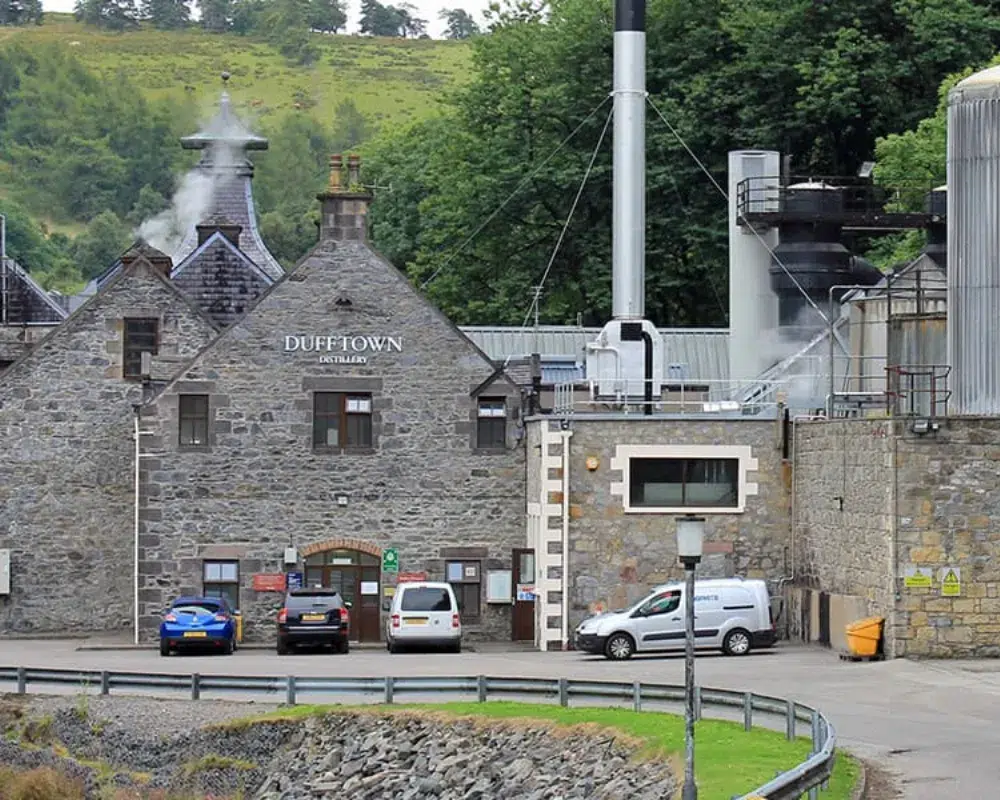 Dufftown whisky distillery exterior with smokestacks.