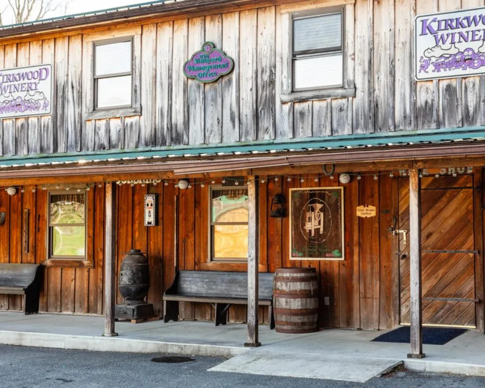 Rustic winery storefront with wooden barrel and signage.