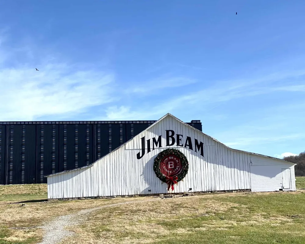 Jim Beam distillery building with logo and wreath.