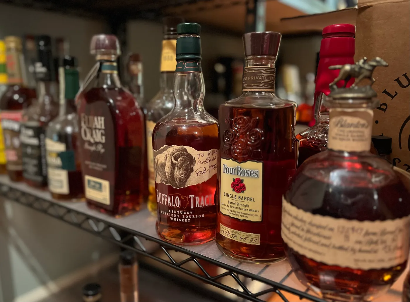 Assorted Kentucky whiskey bottles on a shelf.