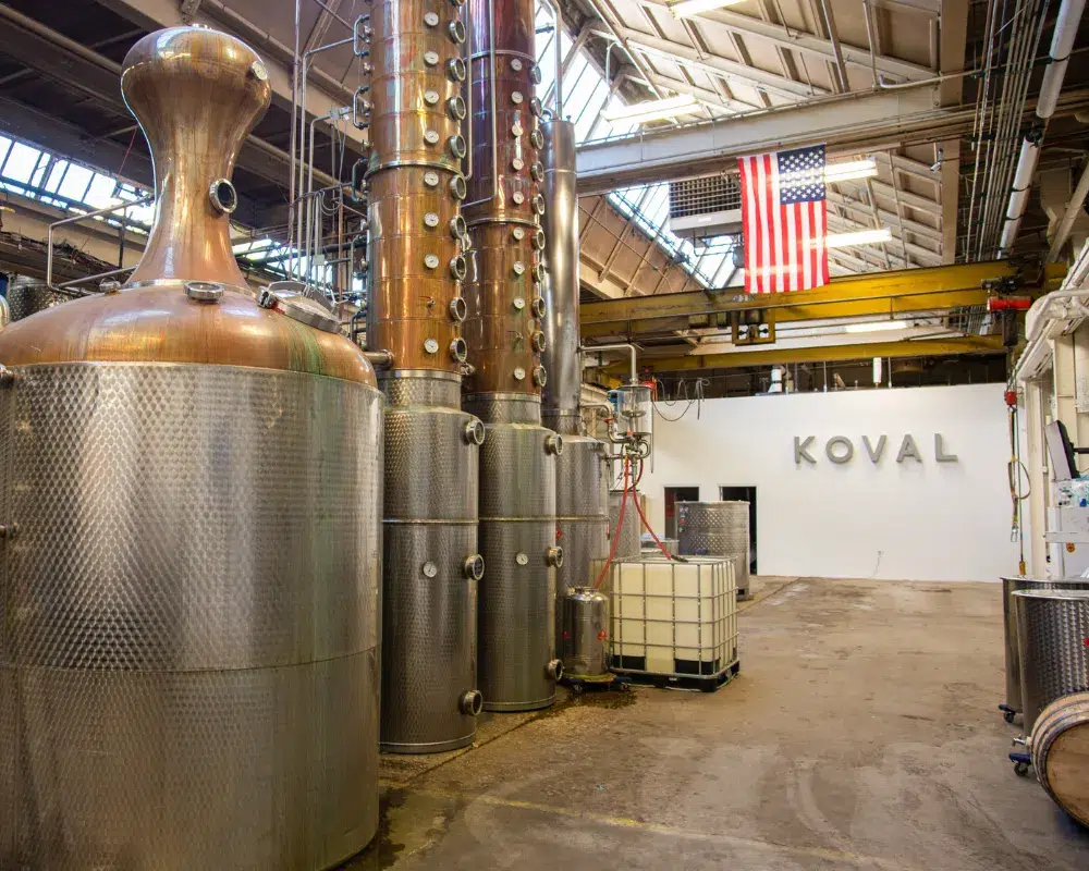 Distillery interior with copper stills and American flag.