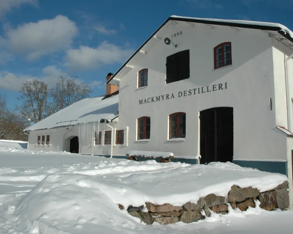 Mackmyra Distillery in snow, white building, blue sky