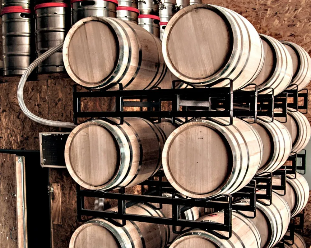 Stacked wooden wine barrels in cellar storage.
