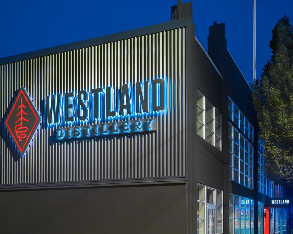 Illuminated Westland Distillery signage at dusk.