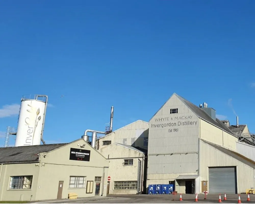 Invergordon Distillery exterior under clear blue sky.