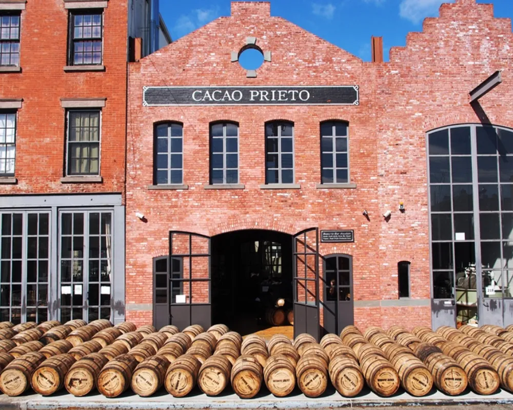 Cacao Prieto distillery facade with stacked wooden barrels.