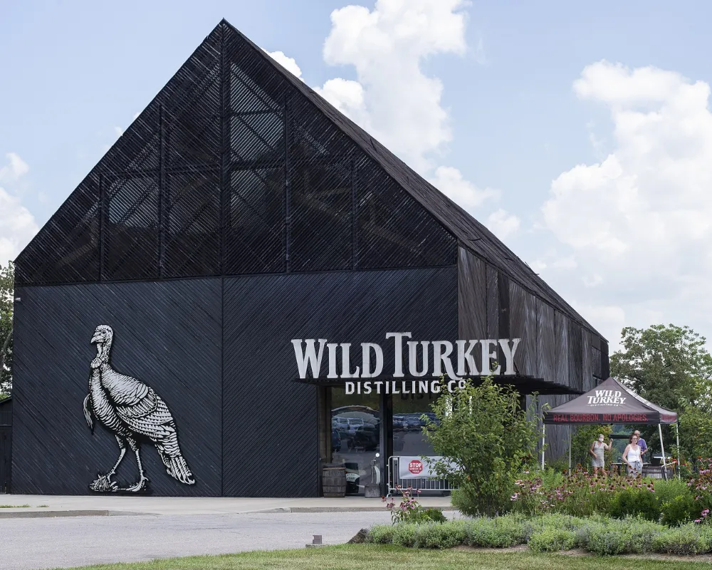Wild Turkey Distillery building facade with logo and visitors.