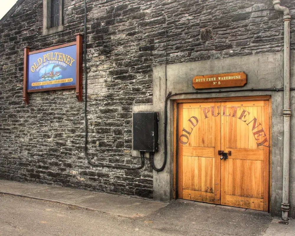 Old Pulteney distillery warehouse entrance with wooden doors.