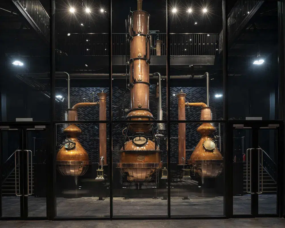 Industrial copper distillation equipment at a distillery.