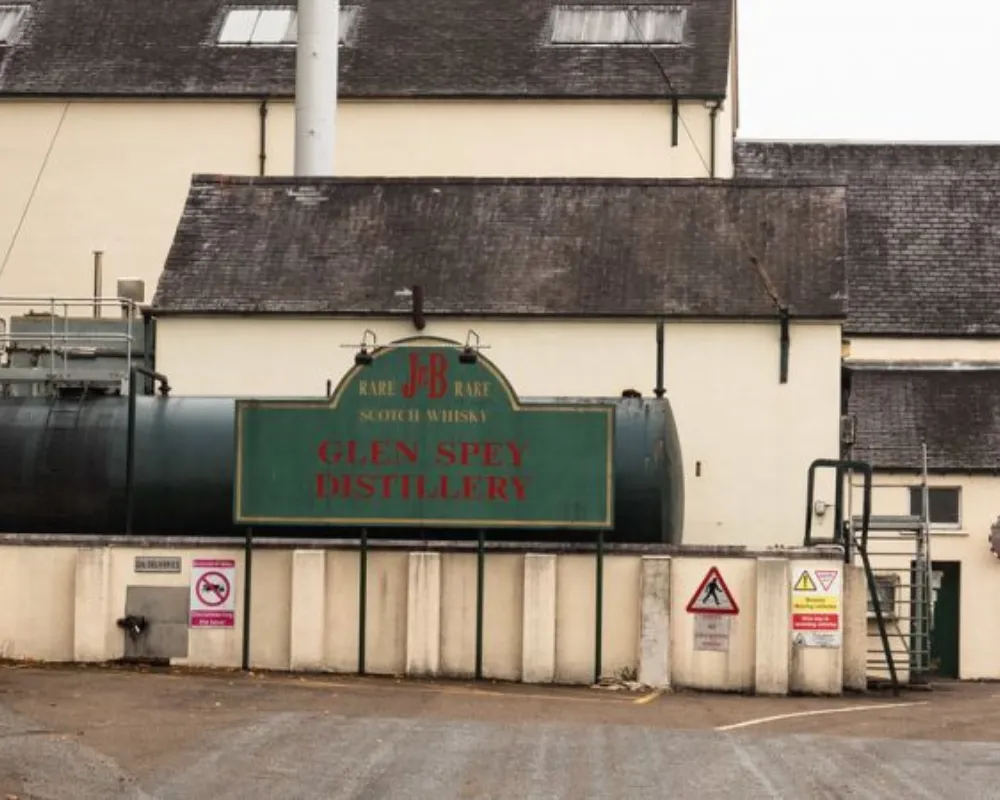 Glen Spey Distillery exterior with signs and storage tank.