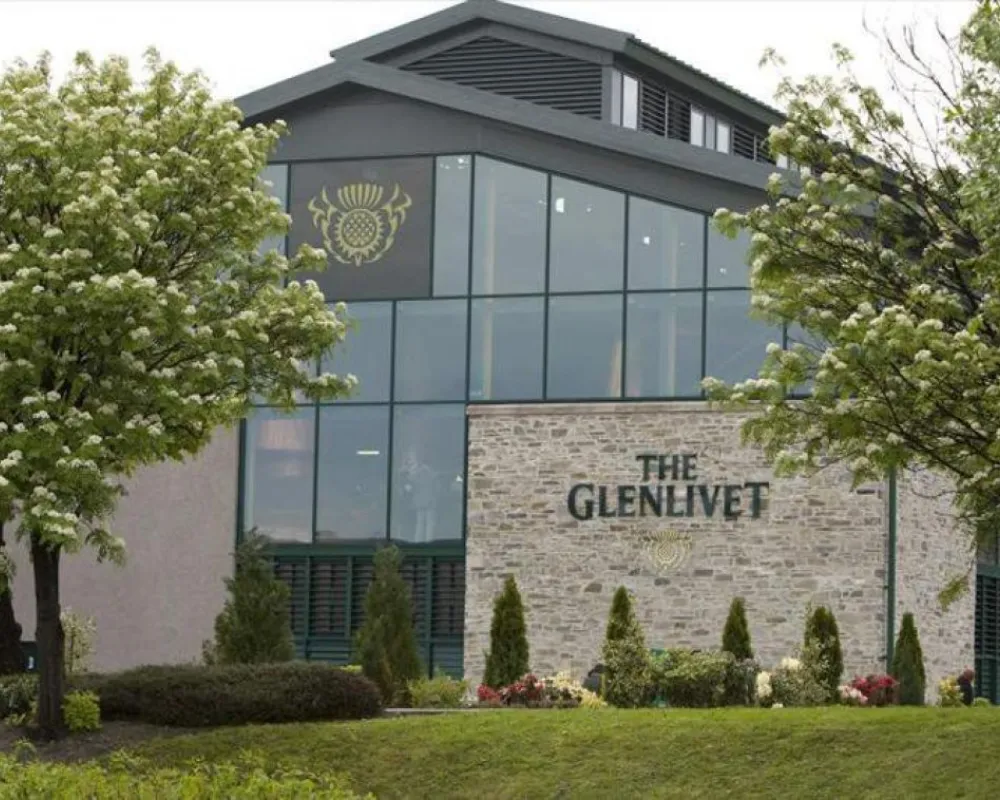 The Glenlivet distillery exterior with blooming trees.