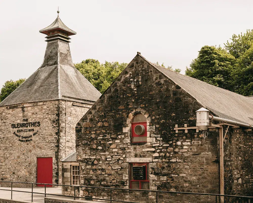 Historic Glenrothes distillery stone building with red doors.