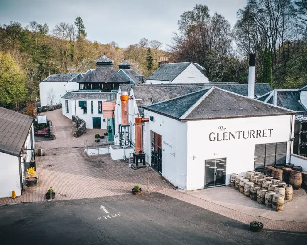 Aerial view of The Glenturret Distillery with barrels outside.