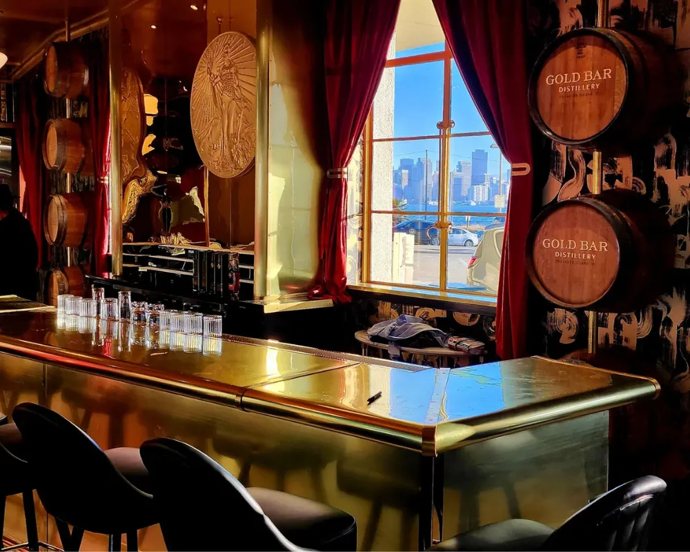 Elegant bar interior with gold accents and city view.