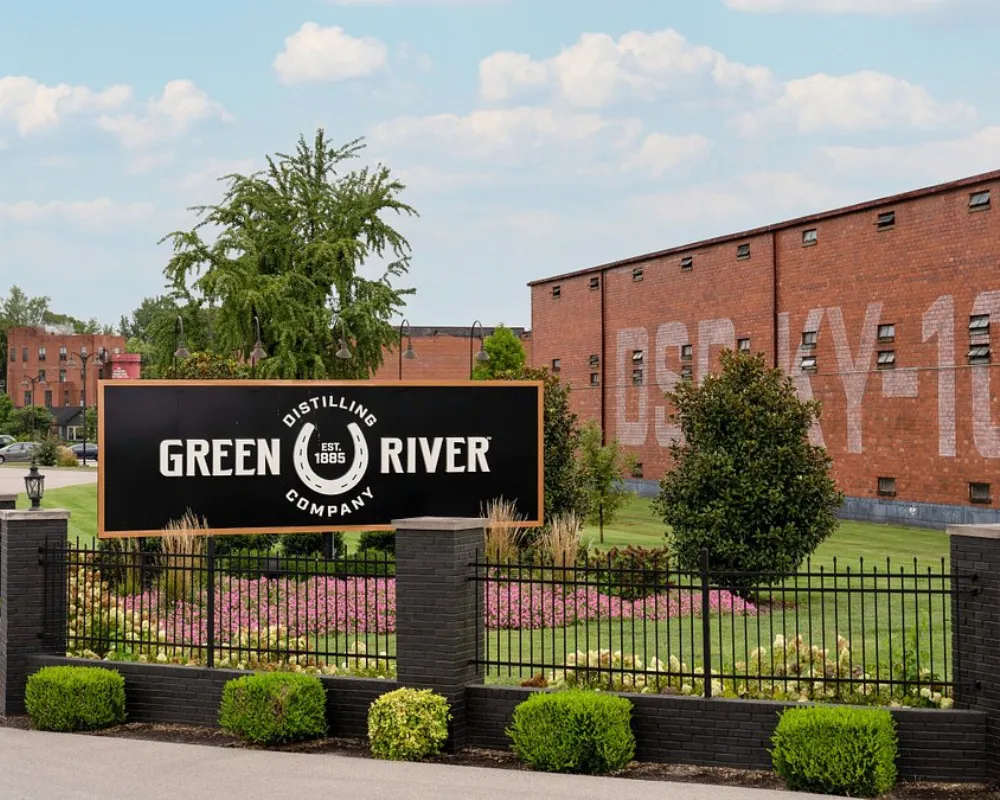 Green River Distilling Company sign with landscaped entrance.