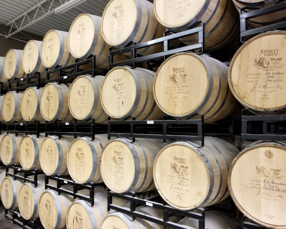 Stacked whiskey barrels in distillery storage.