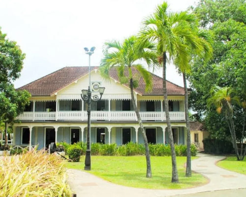 Colonial house surrounded by tropical palm trees.