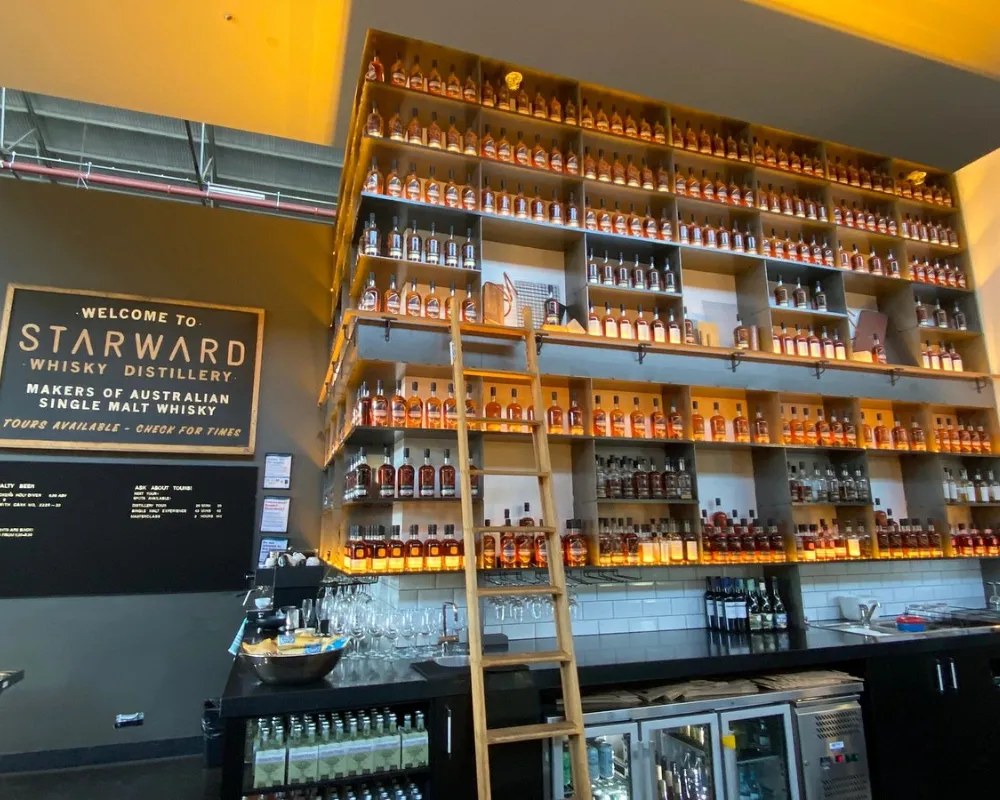 Starward whiskey distillery interior with bottles on shelves.