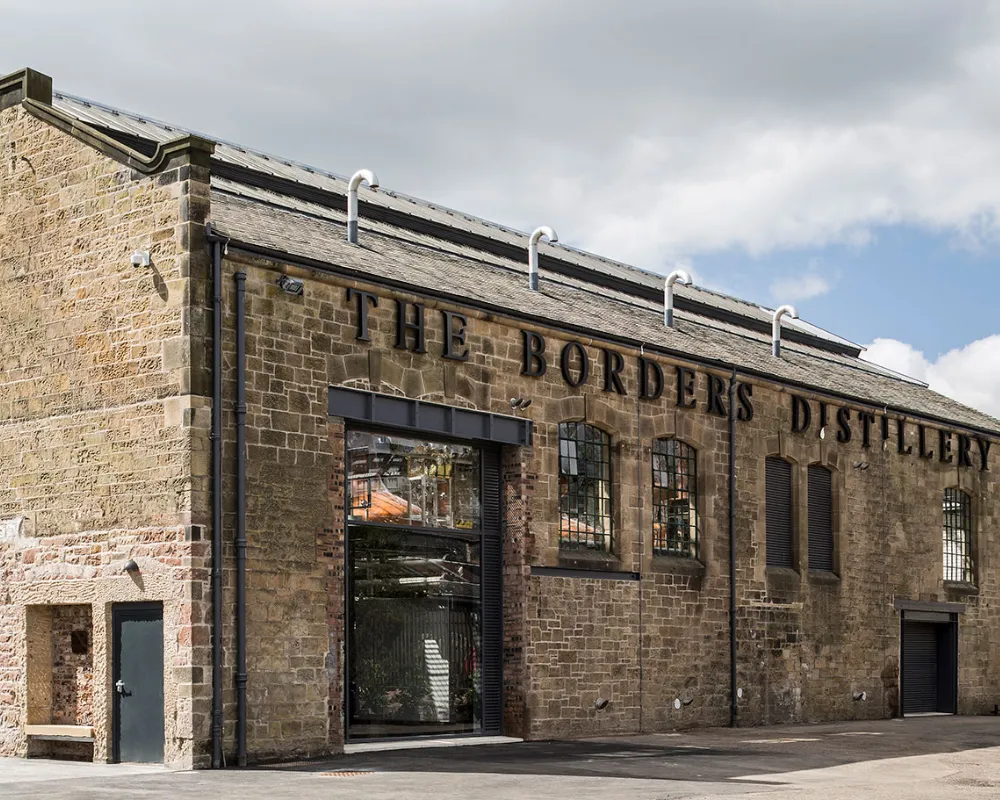 The Borders Distillery exterior, stone building with signage