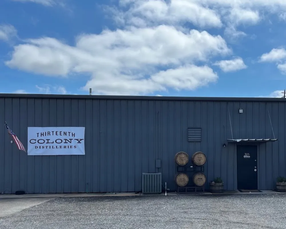 Industrial distillery building with barrels and American flag.