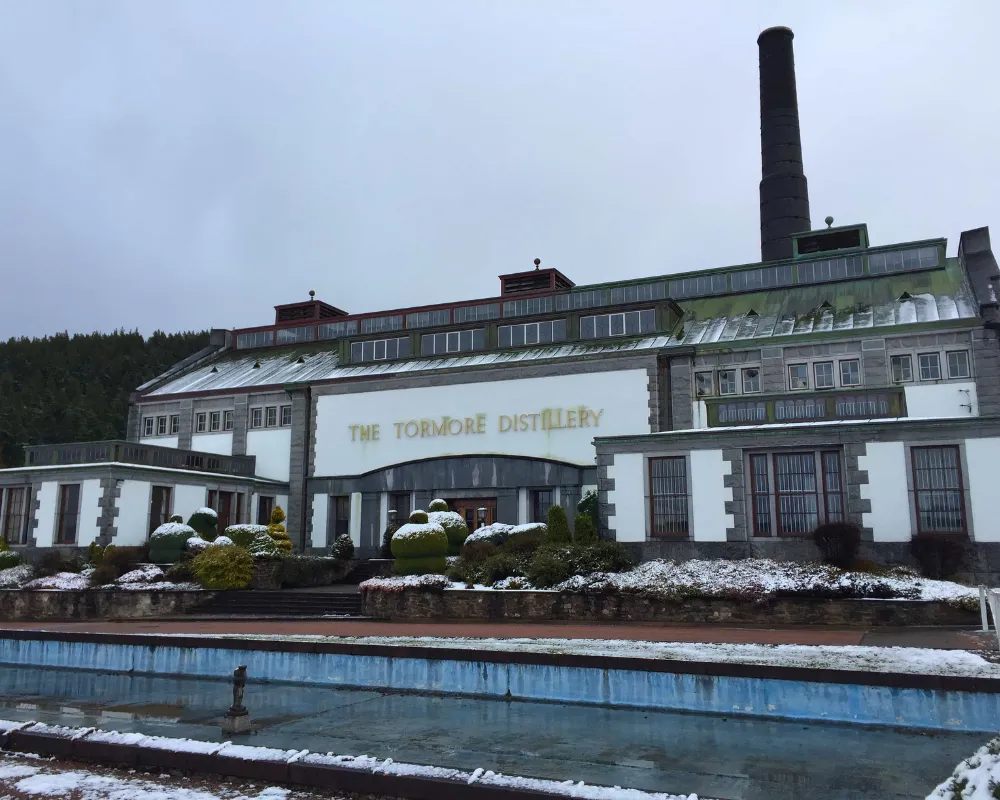 The Tormore Distillery exterior with snow-covered plants.