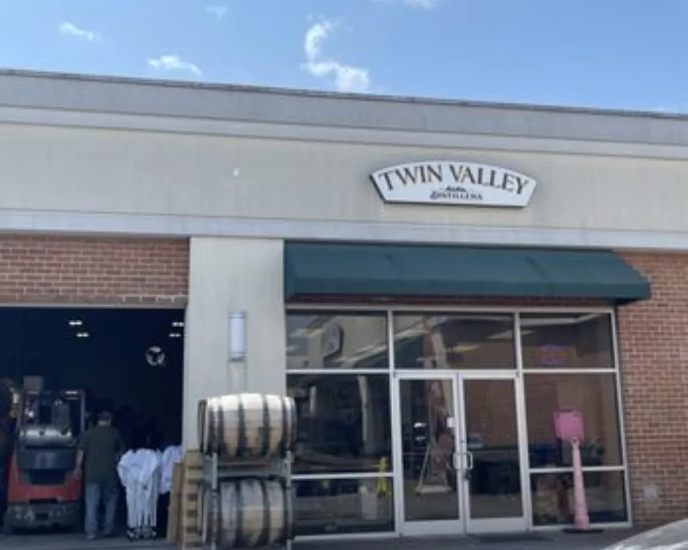 Exterior of Twin Valley Distillery with barrels and staff.
