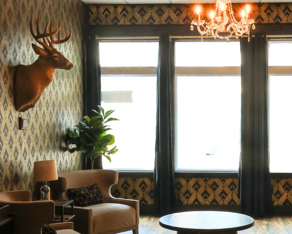 Vintage lounge with deer head and chandelier.
