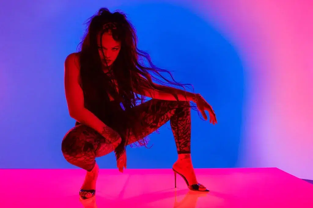 Woman posing in colorful neon lighting.