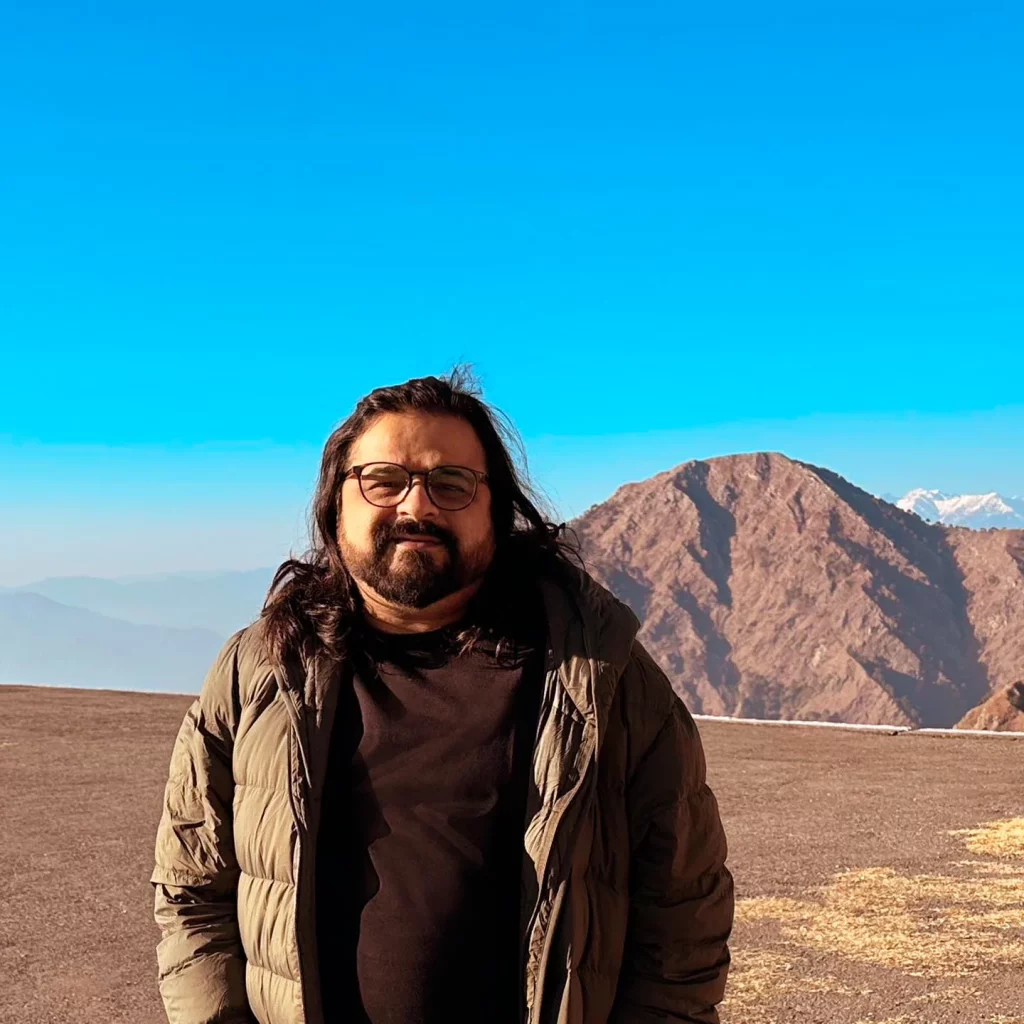 Man smiling in front of mountain landscape