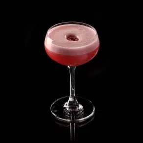 Raspberry cocktail with foam in glass.