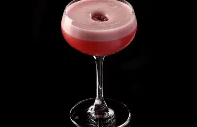 Raspberry cocktail with foam in glass.