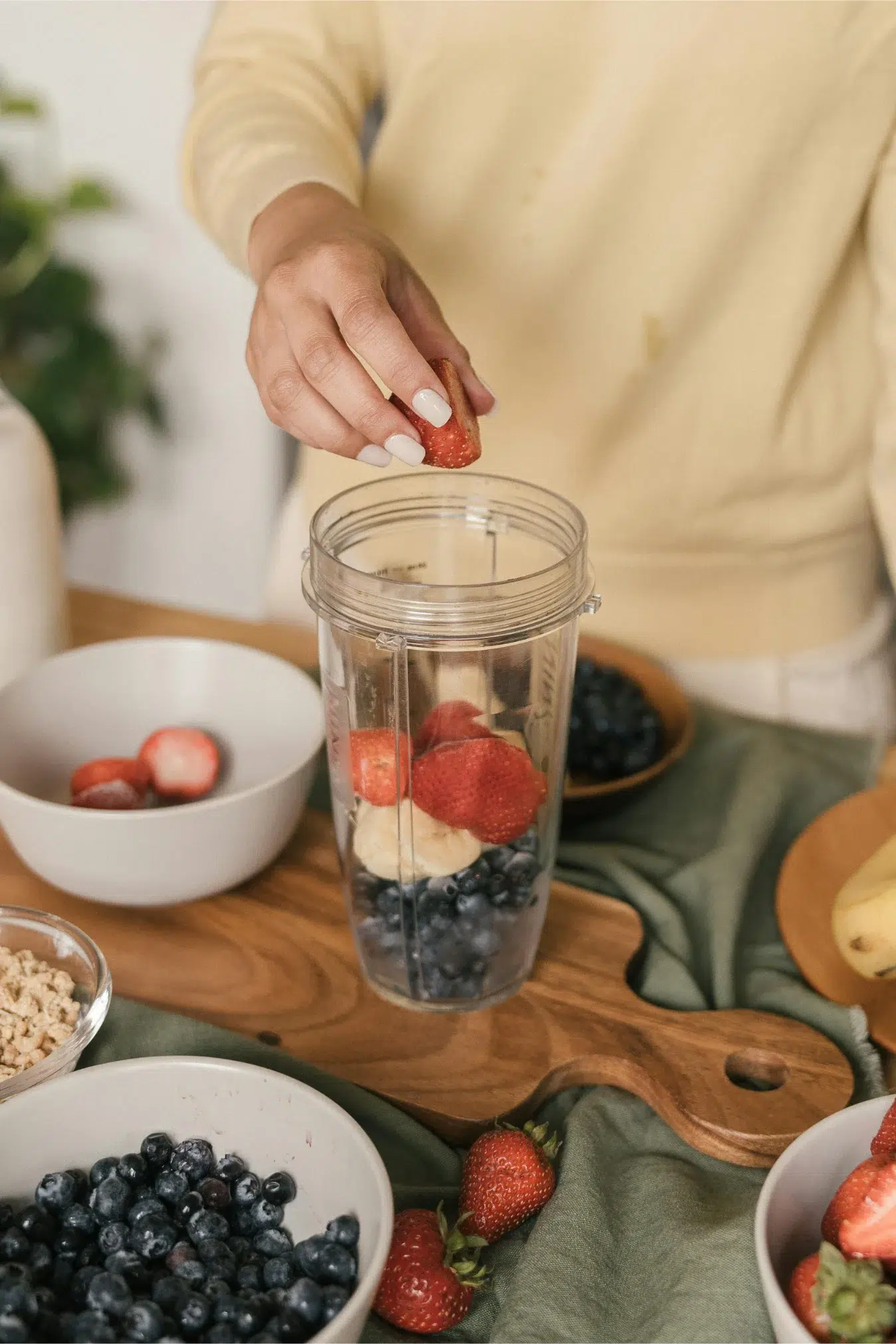 Making smoothie with strawberries, blueberries, and banana.