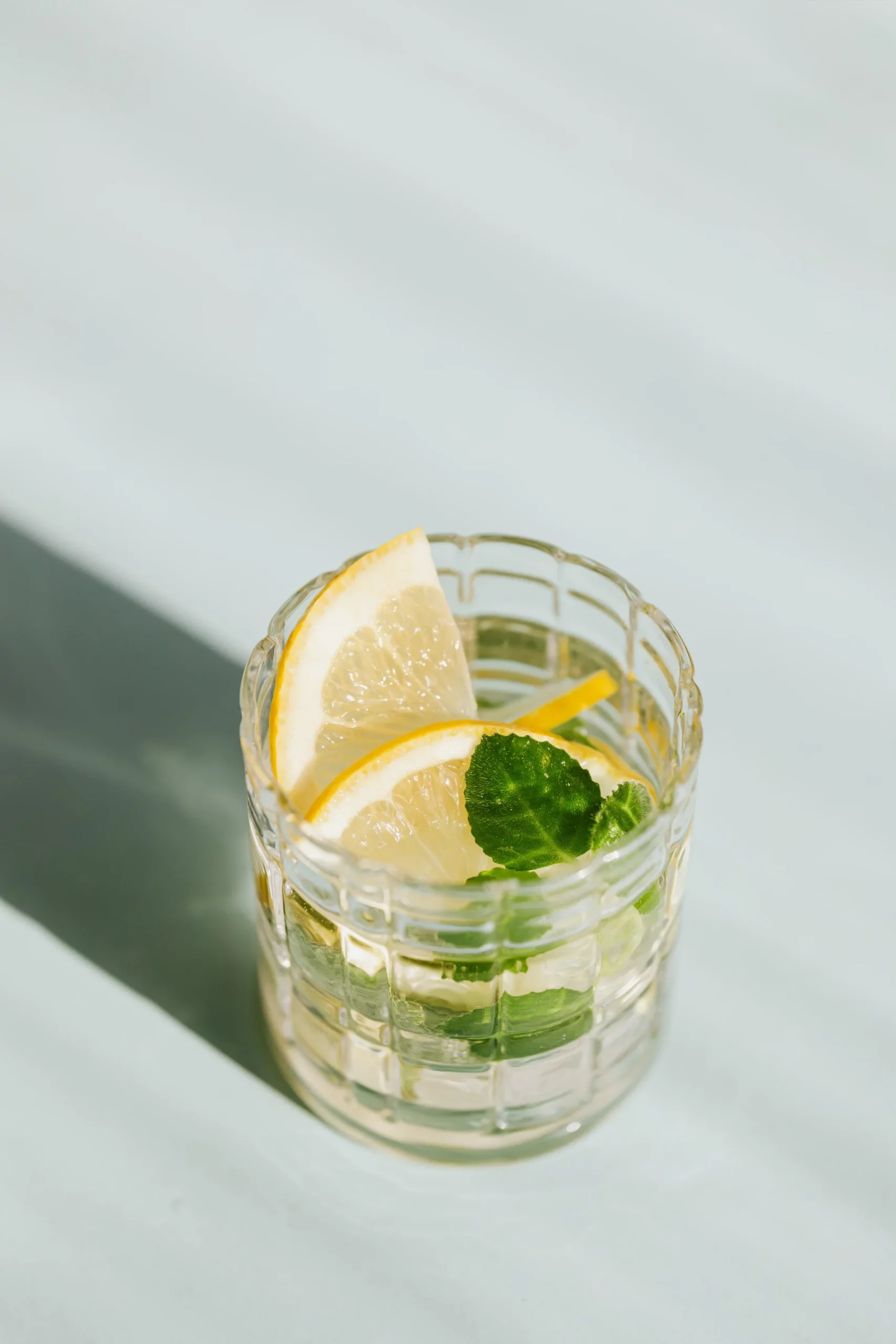 Glass of lemon water with mint leaves