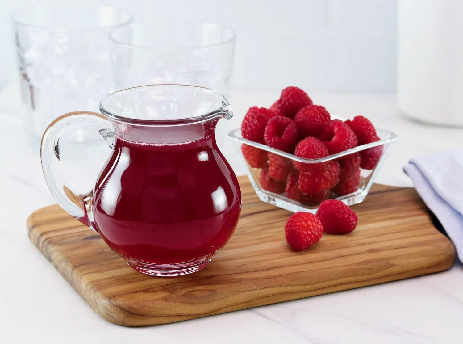 Pitcher of raspberry juice with fresh raspberries